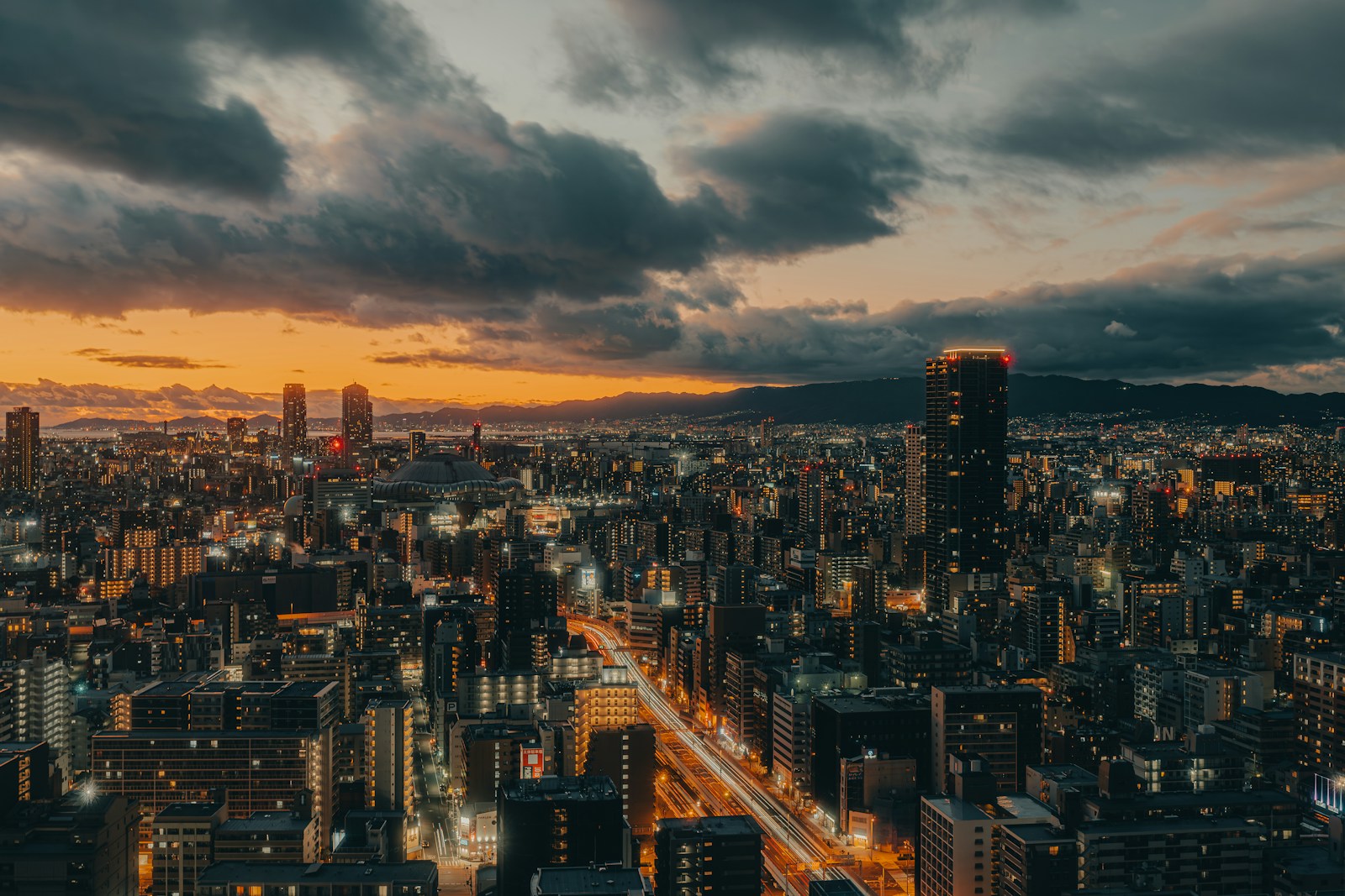 Cityscape at dusk with dramatic clouds and lights